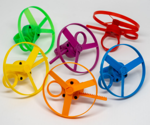 3D gedruckte bunte Propeller Spielzeuge in grün, geld, lila, rot, blau und orange.