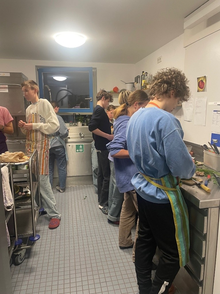 Jugendliche stehen in einer Küche und kochen.